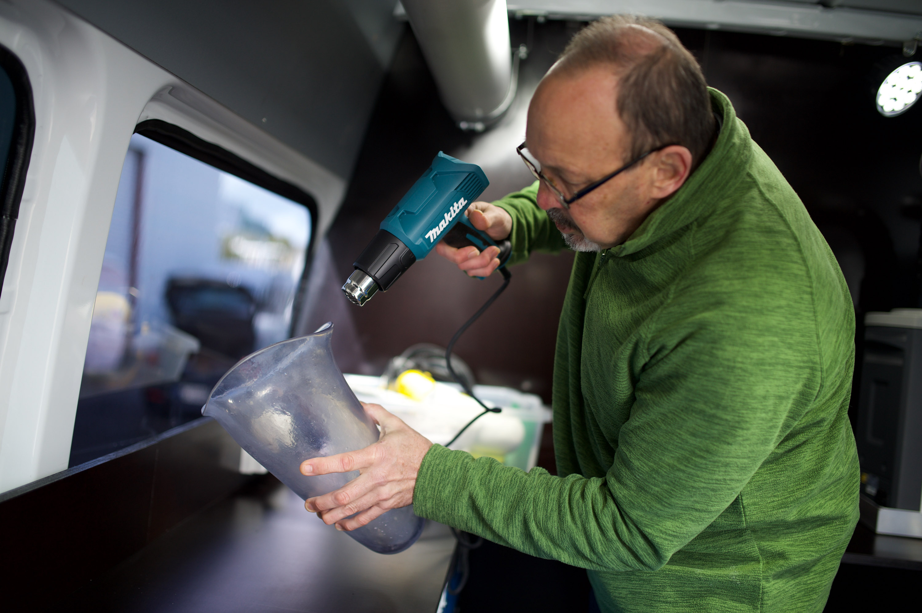 A skill prosthetic technician uses a heat-gun to shape a socket.